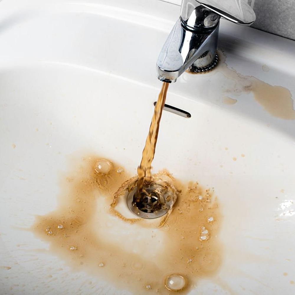 Burst Pipes Discolored, murky water flowing from a bathroom faucet, indicating potential plumbing issues, rust, or contaminated water quality needing inspection by AP Plumbing and Electrical Services