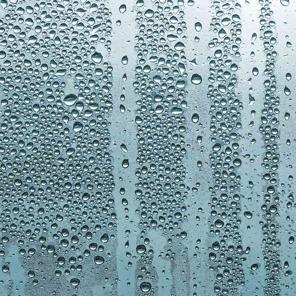 Burst Pipes Condensation and water droplets on a window glass, signifying excess indoor moisture from potential leaks or burst pipes, addressed by AP Plumbing and Electrical Services